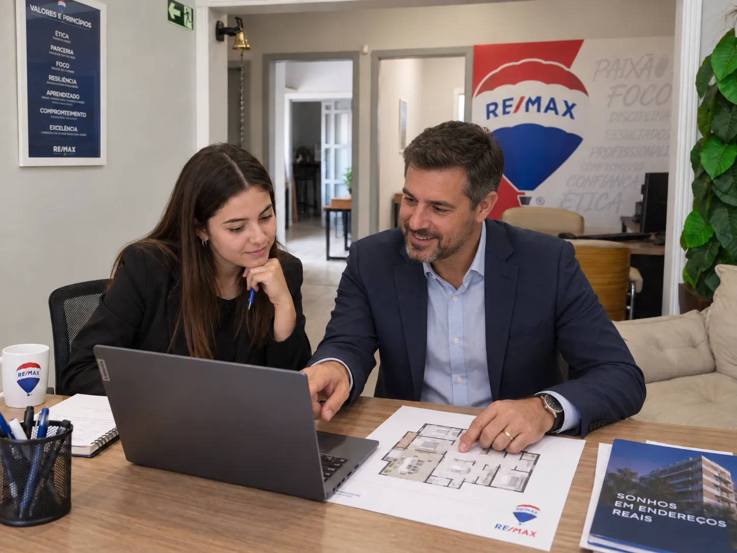 Profissionais da Casa Delta analisando informações de imóveis em um notebook.